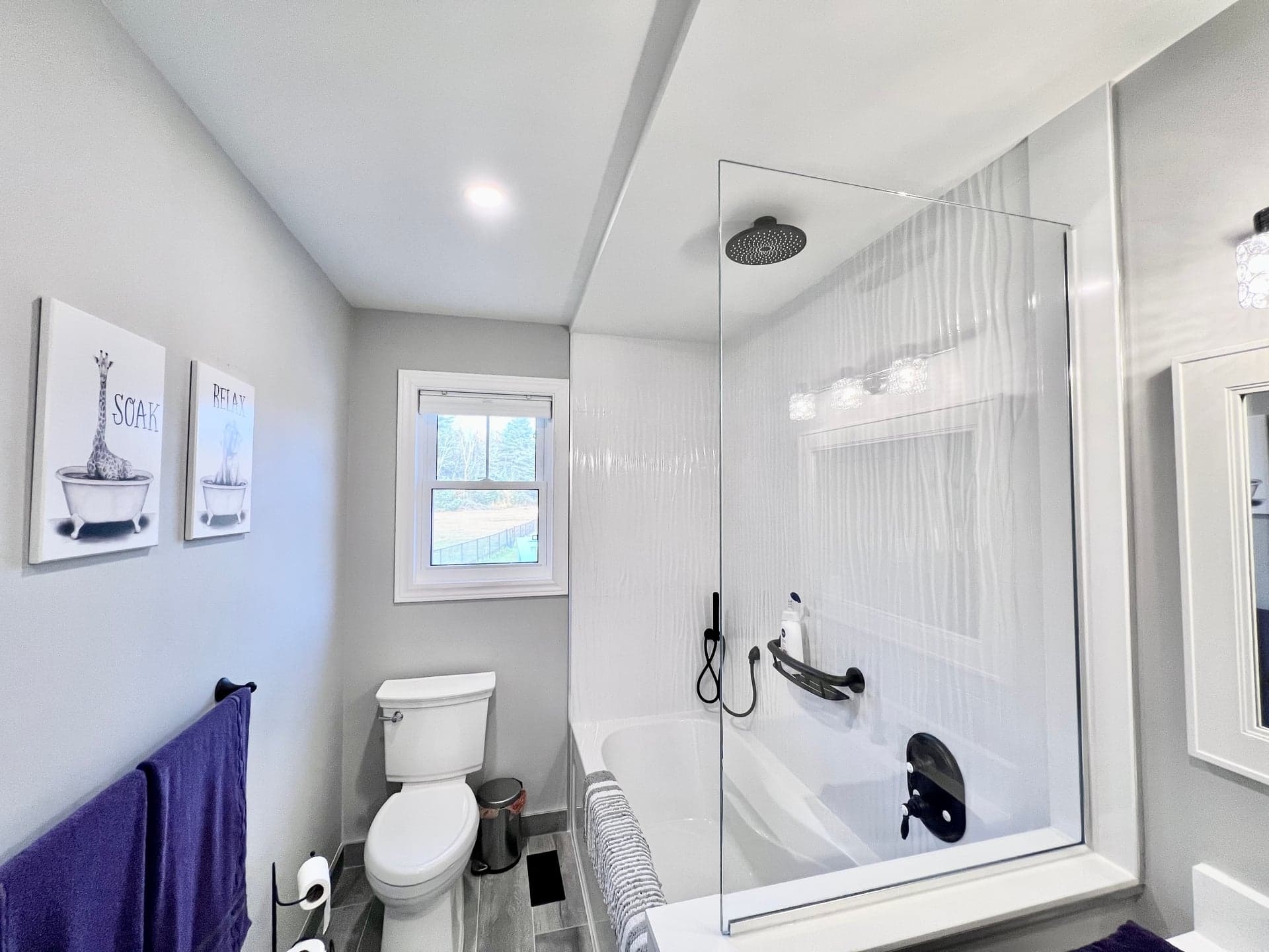 Walk-in shower with textured wavy white tile and glass partition