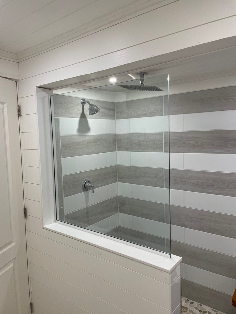 Glass panel shower enclosure with striped tile